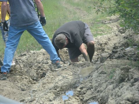 1995 Ford Bronco - People are working in a muddy area, possibly trying to free something stuck.