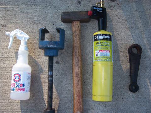 1996 Ford Bronco - A collection of automotive tools and a metal bracket are laid out on a concrete surface.