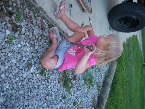 1996 Ford Bronco - A young girl is learning about car maintenance by holding a wrench near a tire.