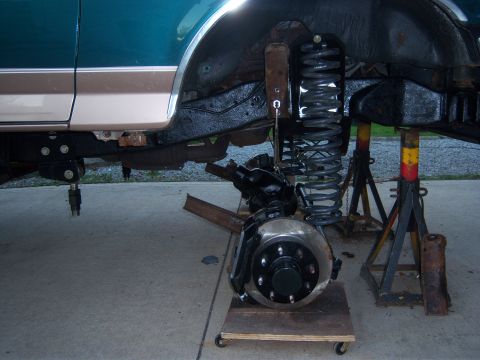 1996 Ford Bronco - The front suspension of a 1996 Ford Bronco is disassembled and supported by jack stands.