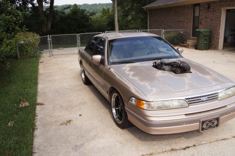 1993 Ford Crown Victoria - This modified 1993 Ford Crown Victoria features a prominent engine cutout in its hood, revealing the supercharged powerplant.