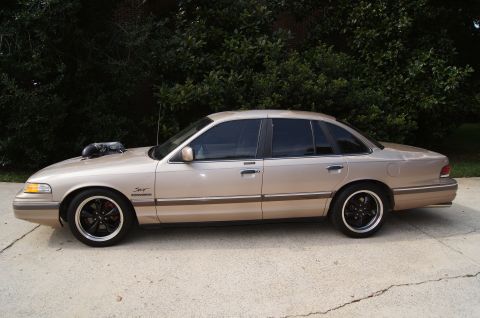 1993 Ford Crown Victoria - This modified 1993 Ford Crown Victoria features a prominent hood scoop and custom black wheels.
