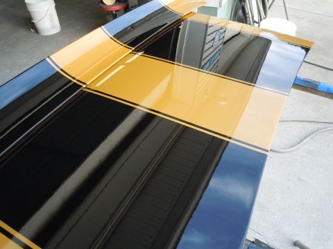 1970 Chevrolet Camaro - Reflective black and gold racing stripes adorn the hood of a 1970 Chevrolet Camaro.