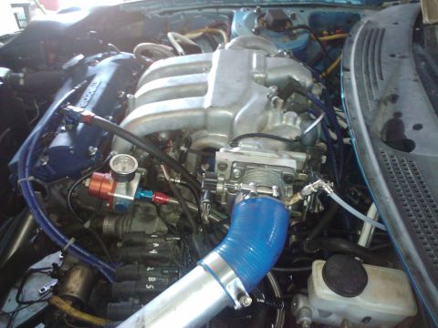 1995 Ford Probe - Close-up view of a modified V6 engine bay, showing custom intake and fuel system components.