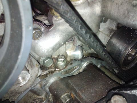 1995 Ford Probe - Engine part detail showing bolts and a drive belt, likely from a car's engine bay.