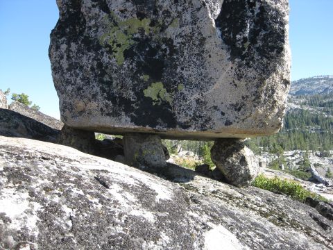 1986 Ford Bronco - A precarious rock formation is seen on a sunny day with trees and hills in the background.