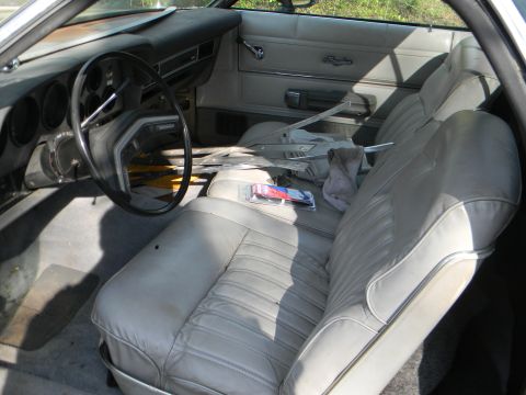 1979 Ford Ranchero - The interior of a 1979 Ford Ranchero shows light-colored seats and dashboard with some clutter.
