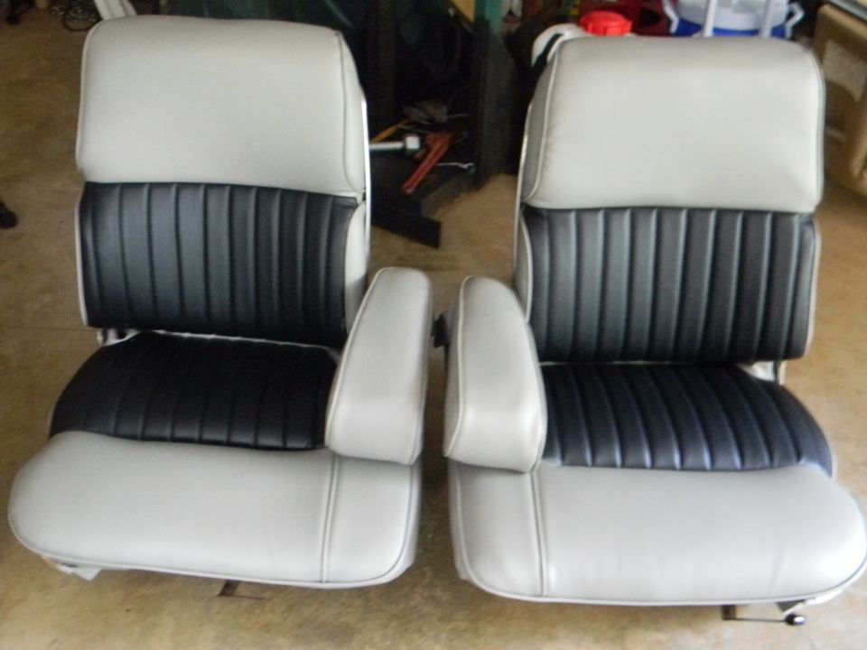Two bucket car seats with light gray outer sections and black pleated inserts