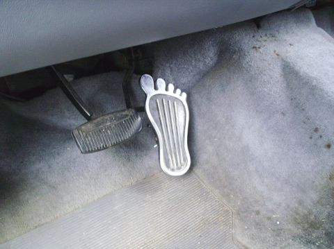 1994 Ford Bronco - The interior of a vehicle shows standard brake and accelerator pedals, with a custom foot-shaped gas pedal cover.