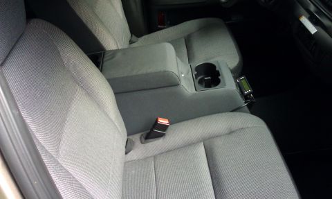 2007 Ford Crown Victoria - Interior view of car seats and center console with a cup holder and electronic device.