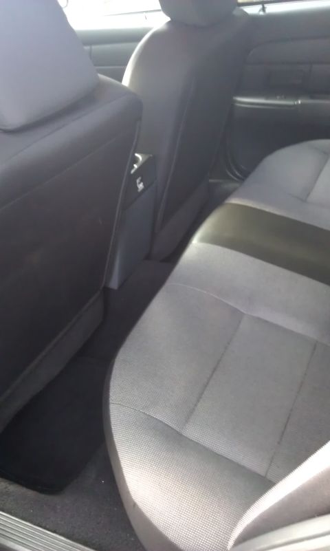 2007 Ford Crown Victoria - Rear interior view of a 2007 Ford Crown Victoria, showing the seats and center console area.