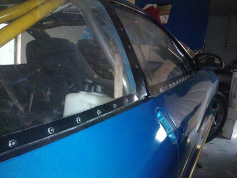 1995 Ford Probe - The interior of a custom-built vehicle shows a roll cage and a white fluid reservoir.
