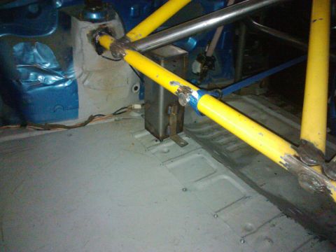 1995 Ford Probe - The interior of a vehicle is visible, a prominent yellow roll cage and blue body panels.