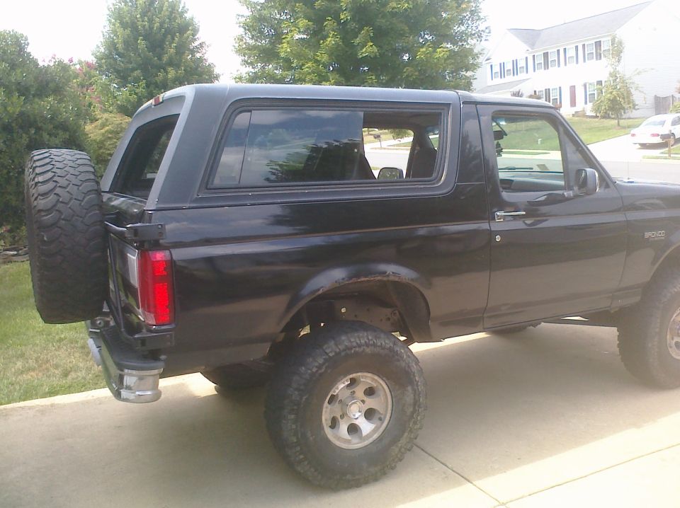 Black 1995 Ford Bronco side view with spare tire mounted on the rear door