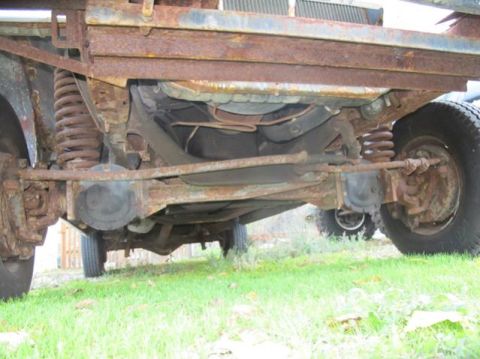 1979 Ford F-150 - Close-up of a heavily rusted truck's undercarriage, showing suspension components and tires.