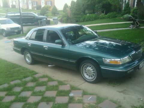 1996 Mercury Grand Marquis - Green 1996 Mercury Grand Marquis sits on a paved driveway next to a grassy lawn.