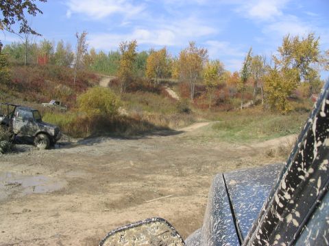 1986 Ford Bronco - Vehicles navigate a muddy off-road course during the fall season.