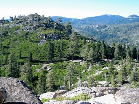 1986 Ford Bronco - Mountain landscape with trees and rocks. The image includes a watermark for SuperMotors.net.