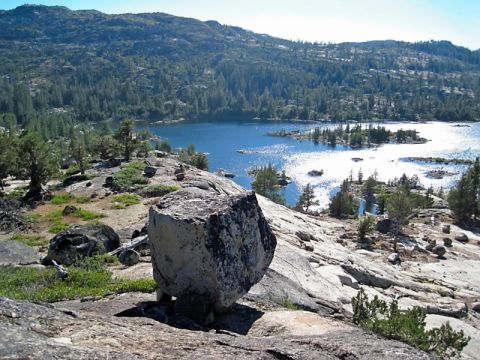 1986 Ford Bronco - A scenic view of a lake surrounded by rocky terrain and evergreen trees on a sunny day.