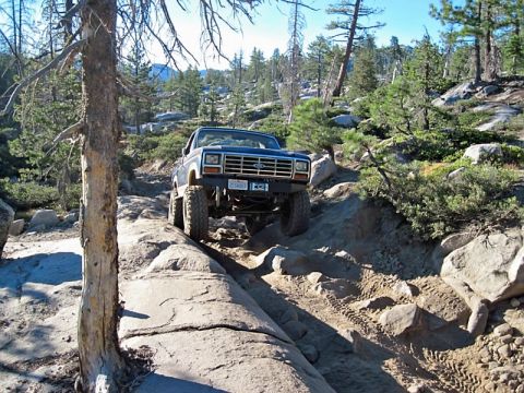 1986 Ford Bronco - Ford Bronco tackling a challenging rocky terrain, its off-road capabilities. The year appears to be around 1980.