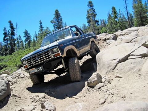 1986 Ford Bronco - This 1986 Ford Bronco tackles a challenging off-road trail with steep inclines and large rocks.
