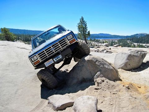 1986 Ford Bronco - This modified Ford Bronco navigates a rocky obstacle course under a clear blue sky.