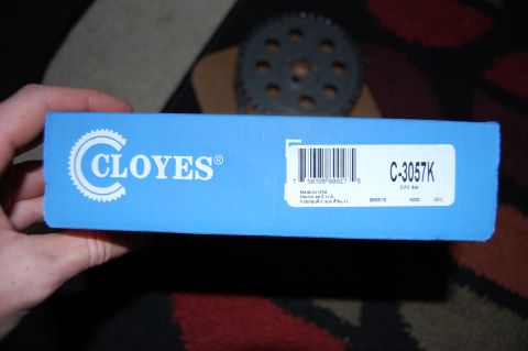 1994 Ford Bronco - A hand holds up a blue Cloyes timing set box labeled C-3057K, 3 PC Set, Made in USA, with the barcode and date code visible. A camshaft tim…