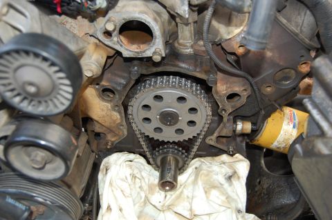 1994 Ford Bronco - In-vehicle view of an engine front with the timing cover removed, exposing the camshaft sprocket, timing chain and crankshaft snout with a…