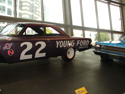 1992 Ford Taurus - Two vintage race cars are displayed indoors, with one 'YOUNG FORD' and the number 22.