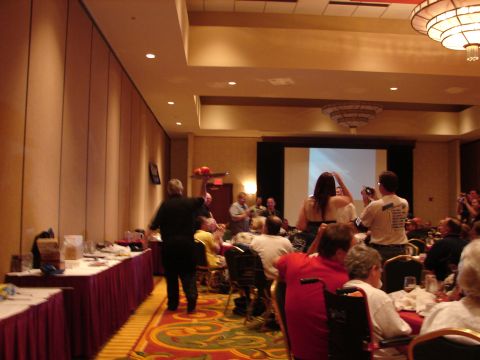 1992 Ford Taurus - Attendees mingle in a convention hall, with a projector screen visible in the background.