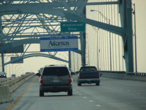 1992 Ford Taurus - Vehicles travel across a bridge, passing a sign indicating the Mississippi River and entry into Arkansas.