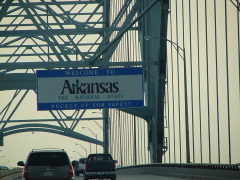 1992 Ford Taurus - Traffic moves across a bridge under a "Welcome to Arkansas" sign.