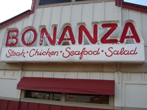 1992 Ford Taurus - Exterior sign for a Bonanza restaurant, advertising its menu items.