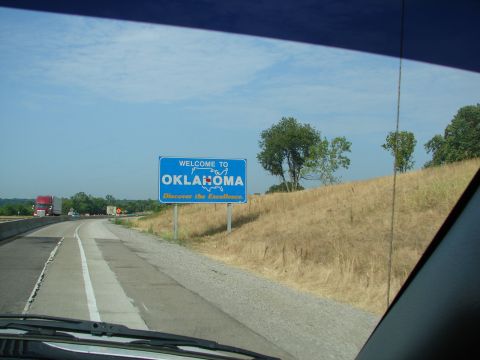 1992 Ford Taurus - Entering Oklahoma on the highway, passing a welcome sign and seeing other vehicles on the road.