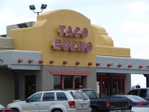 1992 Ford Taurus - A Taco Bueno restaurant with vehicles parked outside under a cloudy sky.