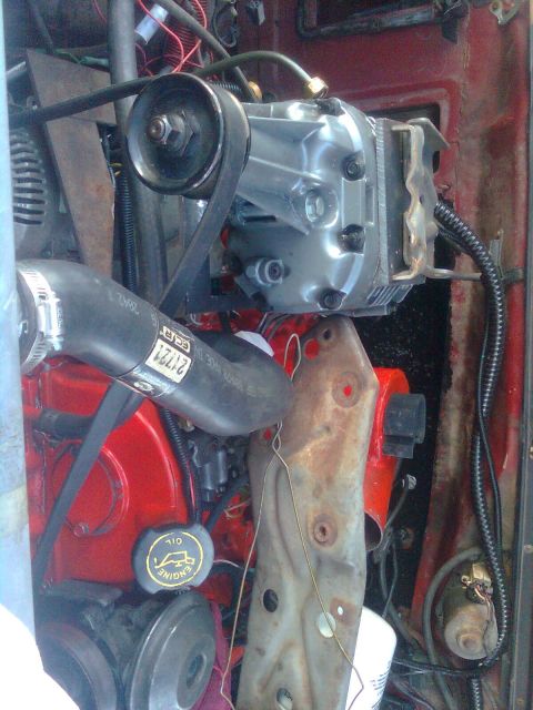 1984 Ford Bronco - Close-up view of an engine bay showing a supercharger installation with various hoses and wiring.
