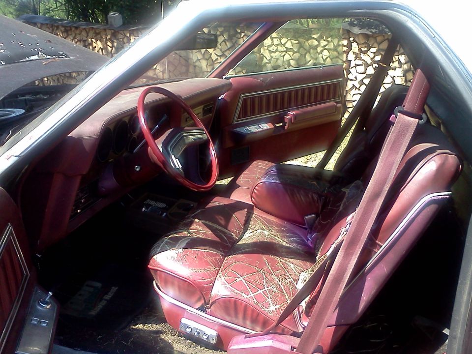 Maroon interior with patterned seats and a red steering wheel