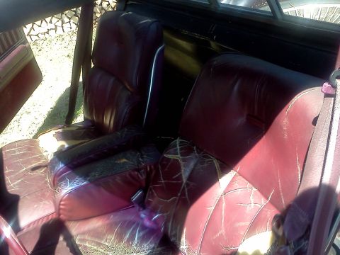 1979 Ford Ranchero - The interior of the vehicle features worn burgundy leather seats and a visible watermark.