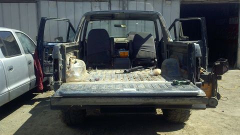 1989 Ford Bronco - This 1989 Ford Bronco is shown from the rear with its doors open, revealing a stripped-down interior.