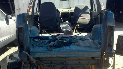 1989 Ford Bronco - Disassembled truck interior and bed with tools laid out, awaiting repair or modification.