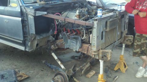 1989 Ford Bronco - Disassembled front end of a gray Ford truck, revealing the engine and chassis components.