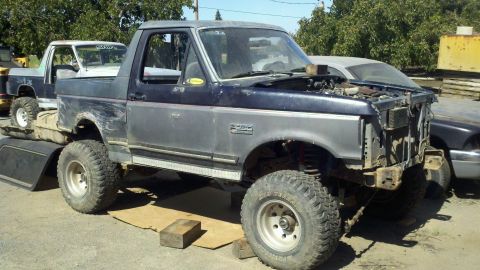1989 Ford Bronco - This lifted Ford Bronco appears to be undergoing some front-end work, with the hood open and grille missing.