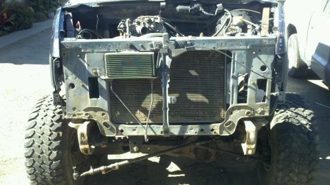 1989 Ford Bronco - The front of an SUV is shown with its grille and bumper removed, exposing the radiator and engine bay.