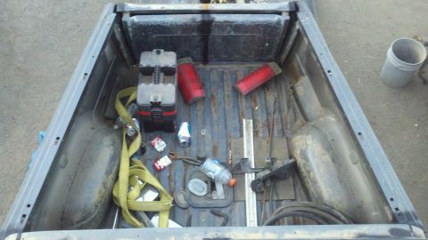 1989 Ford Bronco - The interior of a truck bed is shown with various items scattered inside.