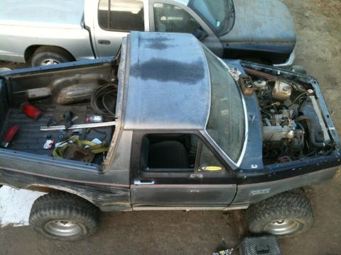 1989 Ford Bronco - This Ford Bronco appears to be undergoing some maintenance with its hood open and parts in the bed.