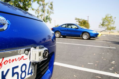 1995 Ford Taurus - A blue coupe is parked in a lot, with a GoPro attached to the front bumper of a blue Nissan in the foreground.