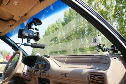 1995 Ford Taurus - Interior view of a car's dashboard with a camcorder and action camera attached to the windshield.