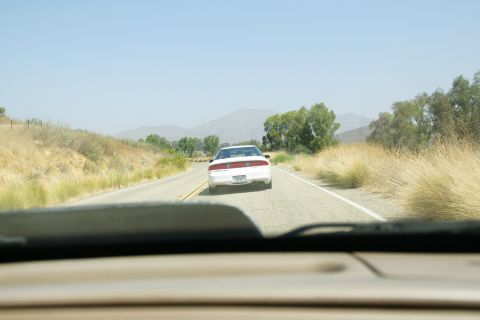 1995 Ford Taurus - Following a white 1995 Ford Taurus on a sunny day on a rural highway.