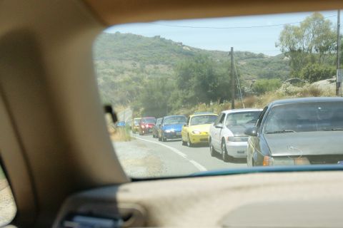 1995 Ford Taurus - A line of cars is stopped on a road, viewed from the perspective of a driver.