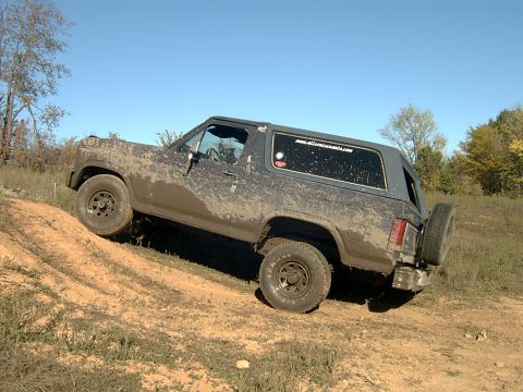 1982 Ford Bronco - This muddy 1980s Ford Bronco tackles an off-road trail on a clear day.